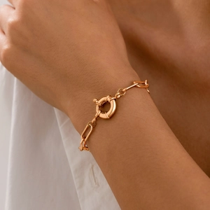Rose gold geometric link bracelet featuring a prominent decorative spring ring clasp
