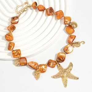Detailed close-up of orange shell beads with golden starfish and sea turtle charms