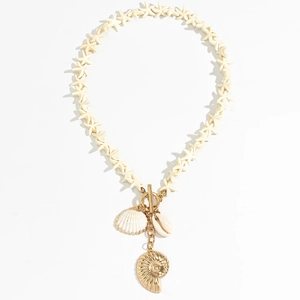 Detail of beach necklace featuring white starfish beads, gold T-bar, and seashell charms