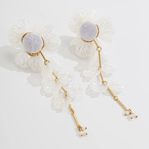Boucles d'oreilles fleurs irisées avec pampilles dorées et perles sur fond blanc pur