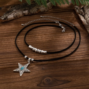 Detail van boheemse turquoise kettingset met sterhanger op rustieke houten achtergrond