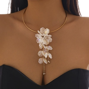 Détail d'un ras-du-cou doré avec des pendentifs fleurs blanches superposées sur un modèle