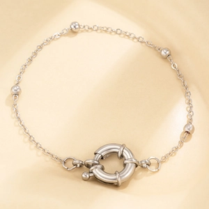 Macro shot of silver minimalist chain bracelet featuring five beads and a large spring ring clasp