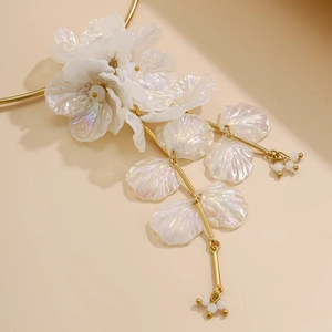 Détail macro de pétales de fleurs irisées et chaîne dorée sur le collier floral