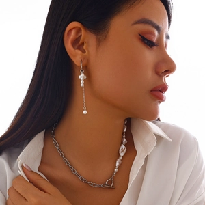 Gros plan d'un ensemble collier de perles baroques et chaîne en métal argenté sur un mannequin