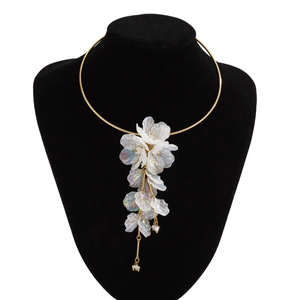 Détail du pendentif fleur irisé blanc sur un collier ras du cou doré élégant