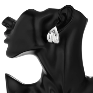 Gros plan de boucles d'oreilles cœur en argent poli sur un support de modèle noir