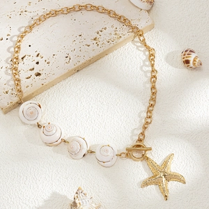 Detail of gold starfish pendant and natural cowrie shells with a vintage toggle clasp