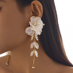 Détail de longues boucles d'oreilles à fleurs avec pétales irisés et perles blanches