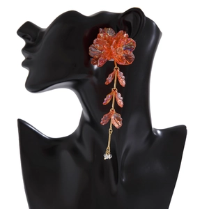 Boucle d'oreille fleurie avec pétales orange translucides sur un mannequin noir