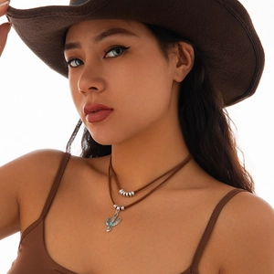 Detail van western stijl halsketting met cactus hanger, turkoois en bruin koord