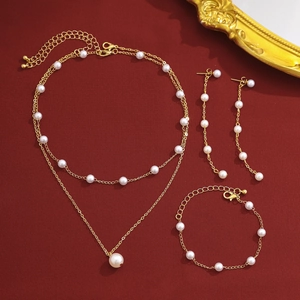 Vue détaillée du parure de bijoux dorée quatre pièces avec perles sur fond rouge élégant