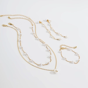 Détail de l'ensemble de bijoux vintage avec collier de perles, bracelet et boucles d'oreilles