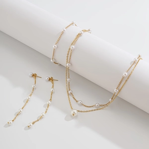 Gros plan d'un collier de perles double épaisseur et de boucles d'oreilles assorties