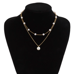 Gros plan du collier double chaîne dorée avec pendentif en perles blanches sur un mannequin