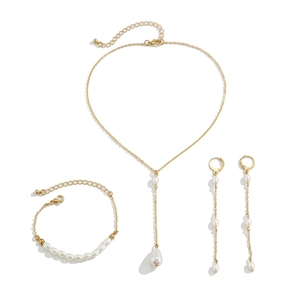Détail d'une parure de bijoux dorée avec collier et bracelet en perles d'imitation