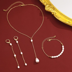 Détail d'une parure en or avec perles blanches sur un fond rouge texturé