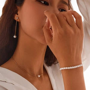 Vue détaillée de l'ensemble de bijoux en perles élégantes avec chaîne dorée et boucles
