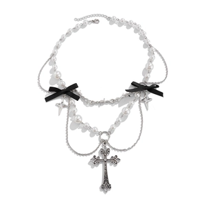 Dettaglio della collana di perle gotica con croce d'argento e fiocco di nastro nero