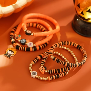 Detail von mehrlagigen Halloween-Tonperlenarmbändern mit Kürbis- und Geist-Anhängern