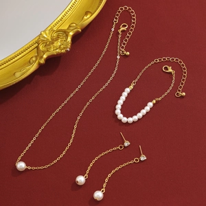 Vue détaillée de l'élégant ensemble de bijoux dorés avec collier, bracelet et boucles