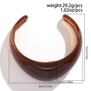 Detail view of amber resin bangle showing dimensions 8cm by 7cm and polished texture