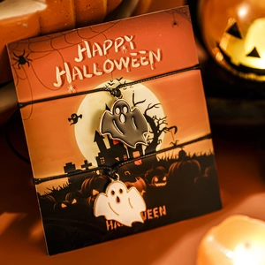 Set di bracciali con ciondoli a fantasma con carta regalo Halloween e sfondo di candele