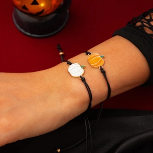 Dettaglio di braccialetti regolabili con zucca in arancione e bianco per Halloween