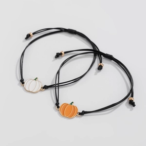 Dettaglio di braccialetti in corda nera regolabili con ciondoli a zucca in smalto arancio