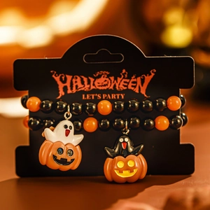 Detailansicht der Halloween-Geister und Kürbis-Anhänger auf orange-schwarzen Armbändern