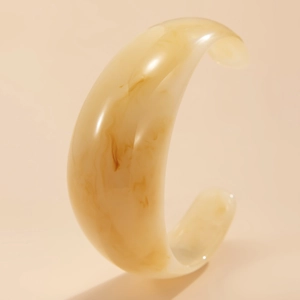 Macro shot of an irregular translucent amber resin bangle with marble texture finish