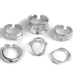 Dettaglio del set di 6 anelli geometrici argento con design a pieghe e forme irregolari