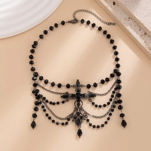Close-up of gothic black beaded choker with tassel chains and cross metal pendant detail