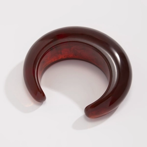 Detailed view of the deep wine red acrylic bangle featuring a polished marbled texture
