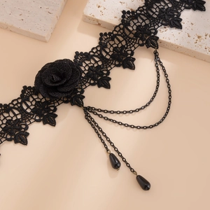 Detalle de gargantilla gótica de encaje negro con rosa y colgantes de cristal en forma de gota