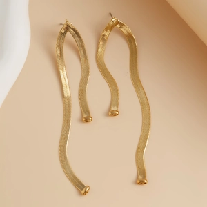Macro view of gold snake chain earrings featuring smooth textures and glossy metal plating