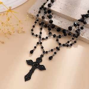 Detail view of a gothic beaded choker featuring a vintage filigree cross pendant