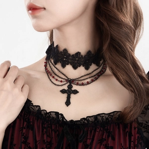 Detail of gothic black lace choker with red beads, layered chains, and cross pendant