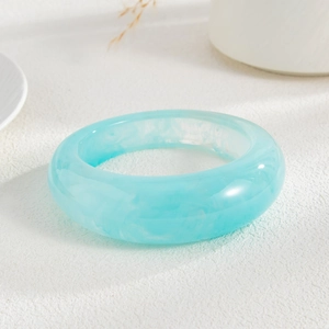 Detailed macro view of a wide turquoise marble resin bangle with elegant cloud textures