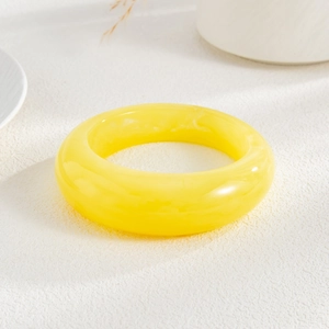 Macro shot of smooth translucent yellow acrylic resin bracelet with polished finish