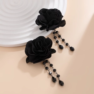 Detail of gothic black rose fabric earrings with beaded fringe tassels on display stand