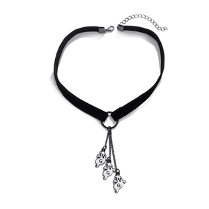 Dettaglio di choker gotico in velluto nero con catena luna e ciondoli a fantasma