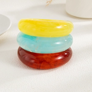 Detailed stack of three multi-color resin bangles with acrylic marble texture and smooth finish