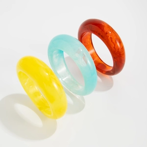 Macro shot of stylish acrylic bangles with marble texture in yellow, blue and amber