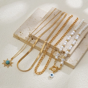 Detail von Boho-Goldkette mit Sonnen-Türkis und Perlenkette mit Bösem Blick
