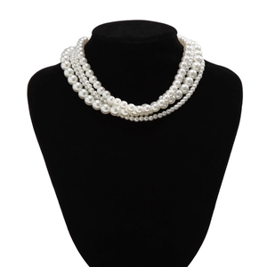 Close-up van een meerlaagse witte parelketting met vier strengen op een displaybuste