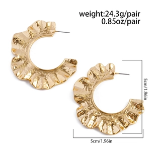 Détail de créoles dorées de 5cm avec design plissé effet soleil et texture martelée
