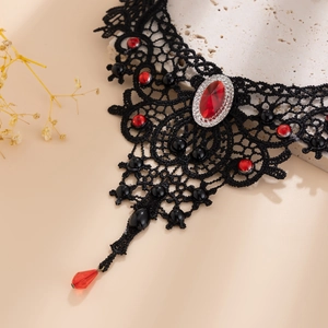 Detail eines gotischen schwarzen Spitzen-Chokers mit rotem Edelstein für Halloween