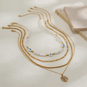 Detailansicht der mehrlagigen Goldkette mit Sonnenmond-Anhänger und blauen Perlen