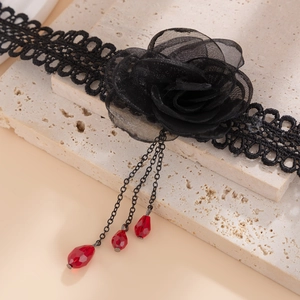 Detalle de gargantilla gótica de encaje negro con rosa de tul 3D y cristales rojos